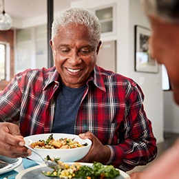 Senior man filling plate at table