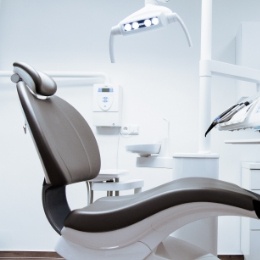Dental chair in dental office with pristine white walls