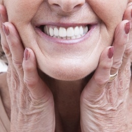 Close up of smiling senior woman holding the sides of her face