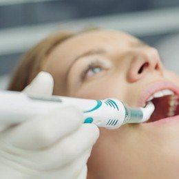 Dentist scanning a patient's mouth for cavities