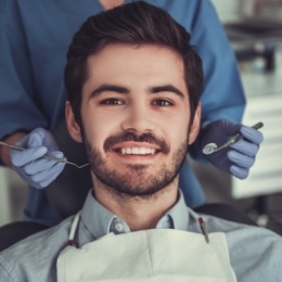 Young man with short beard sitting in dental chair