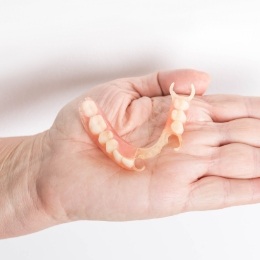 Hand holding a partial denture