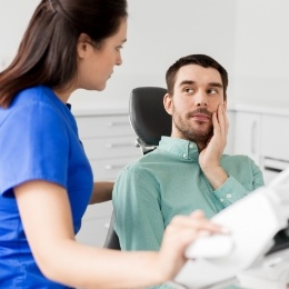 Man in dental chair talking to his emergency dentist in Nepean