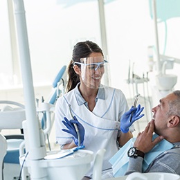 Dentist explaining procedure to patient in treatment chair
