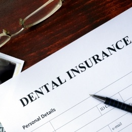 Dental insurance form on dark wood table