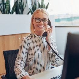 Smiling dental team member talking on phone