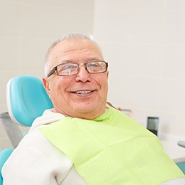 Senior man sitting in a dental chair smiling