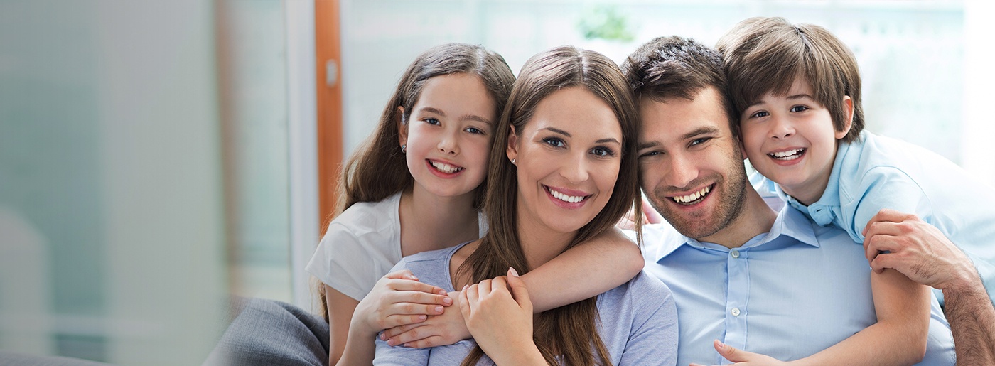 Smiling family of four sitting on couch