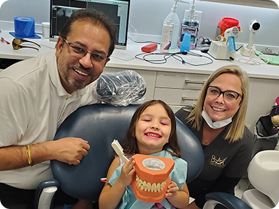 Doctor Bal with smiling child in dental chair