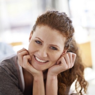 Redheaded woman with ponytail smiling with straight teeth thanks to orthodontics in Nepean