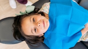 Child smiling while laying in dental chair