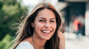 Woman smiling outdoors with her hair blowing in the wind