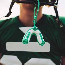 Athletic mouthguard hanging from football helmet