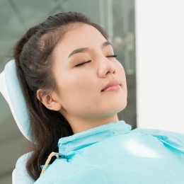 Young woman relaxing in dental chair with eyes closed