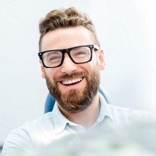 Bearded man smiling in dental chair