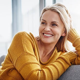 Woman smiling while relaxing on couch