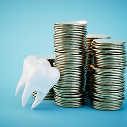 Model of a tooth next to a stack of coins