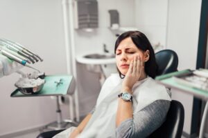 Woman in pain in dentist's chair.