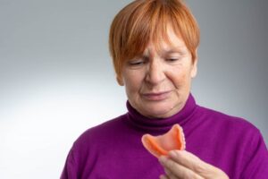 Woman looking at her bad smelling dentures