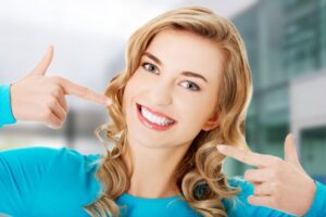Woman smiling widely with straight, white teeth.