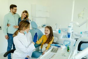 Parents and their young daughter visiting their dentist